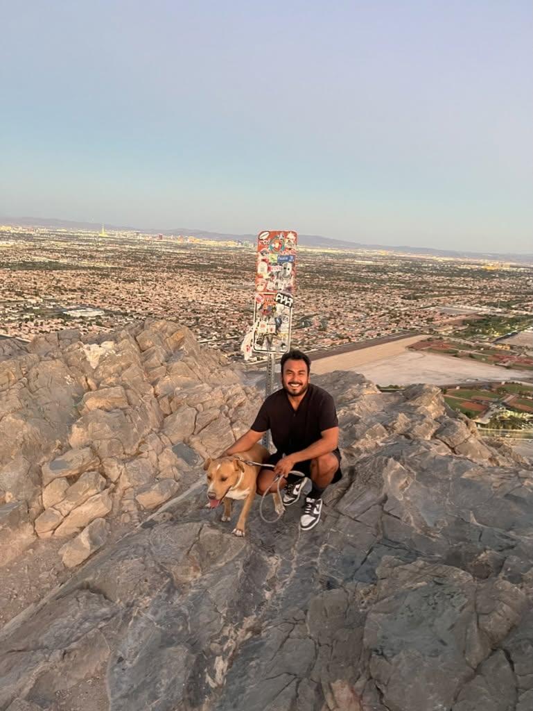 Abimael Duran, Founder & Managing Member of SNV Properties, on a Nevada trail with his dog overlooking Las Vegas